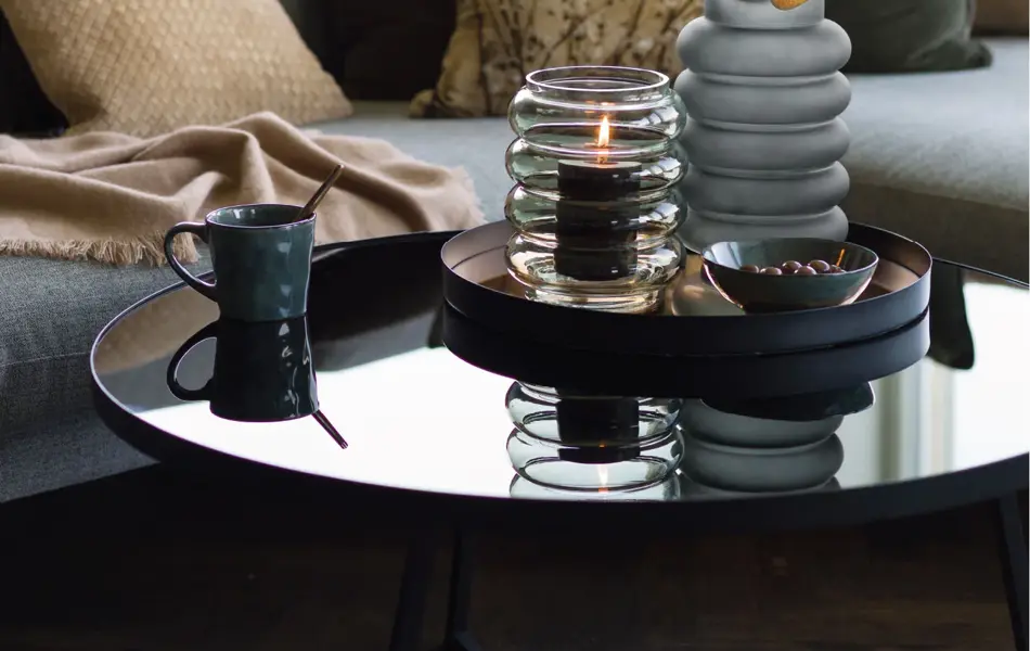 Sofa med bord dekket med vase med en kvist