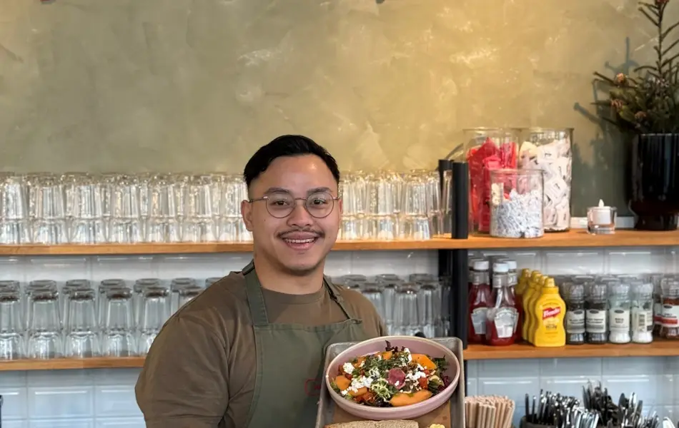 Mann hoiilder frem salat hos jordbærpikene