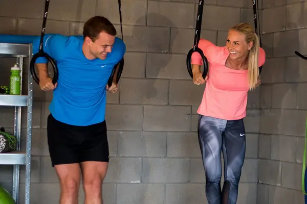 mann og dame trener med opphengte ringer