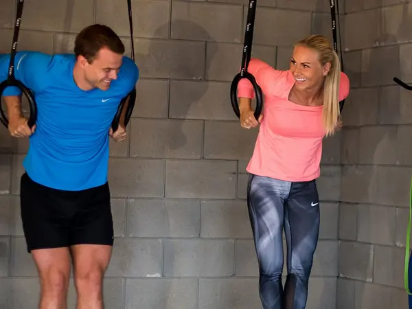 mann og dame trener med opphengte ringer