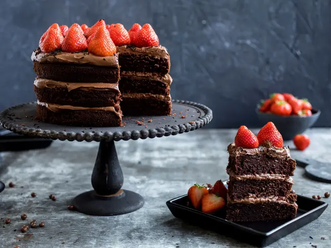 Fat med sjokoladekake i tre lag med jordbær på toppen