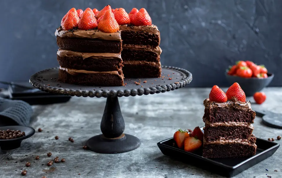 Fat med sjokoladekake i tre lag med jordbær på toppen