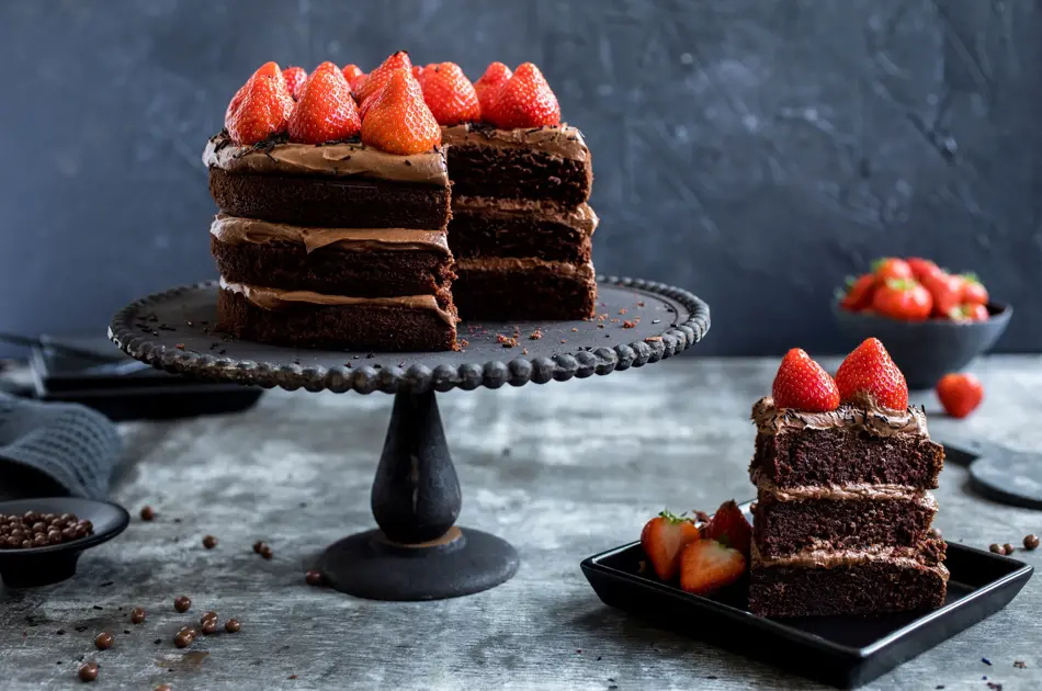 Fat med sjokoladekake i tre lag med jordbær på toppen