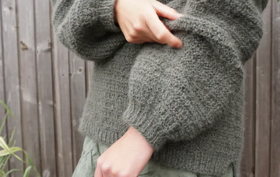 Dame med skjørt og grønn strikkegenser