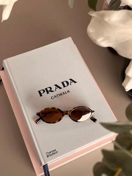 Solbriller som ligger på en bok om Prada
