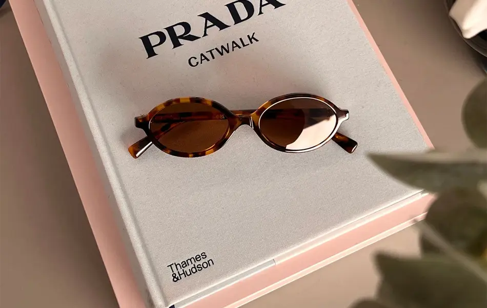 Solbriller som ligger på en bok om Prada