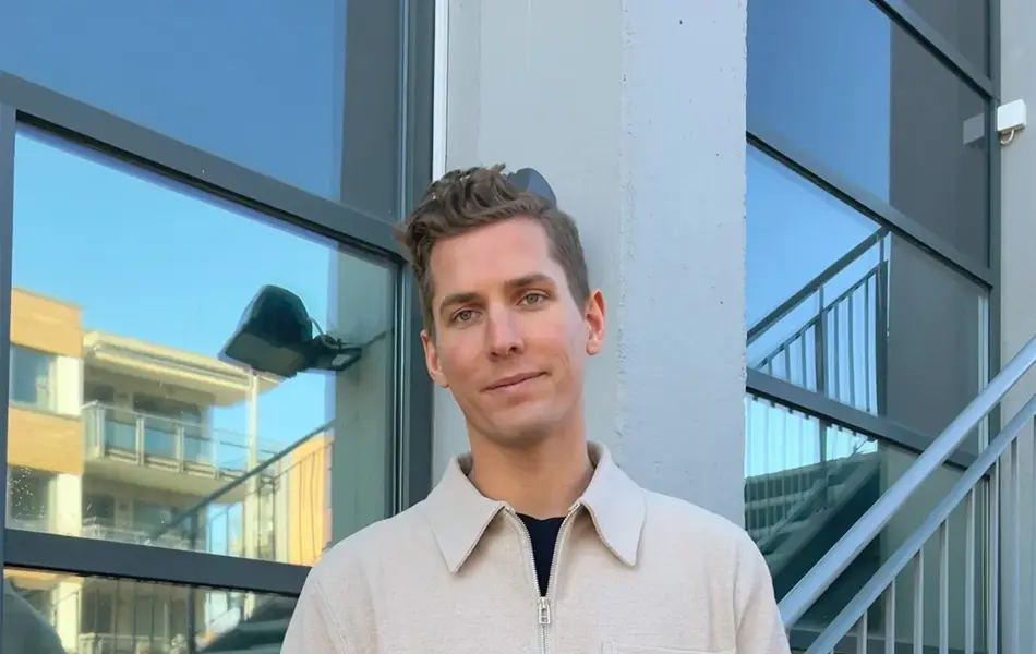 Menn med beige genser som smiler