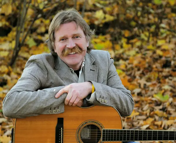 smilende mann med gitar