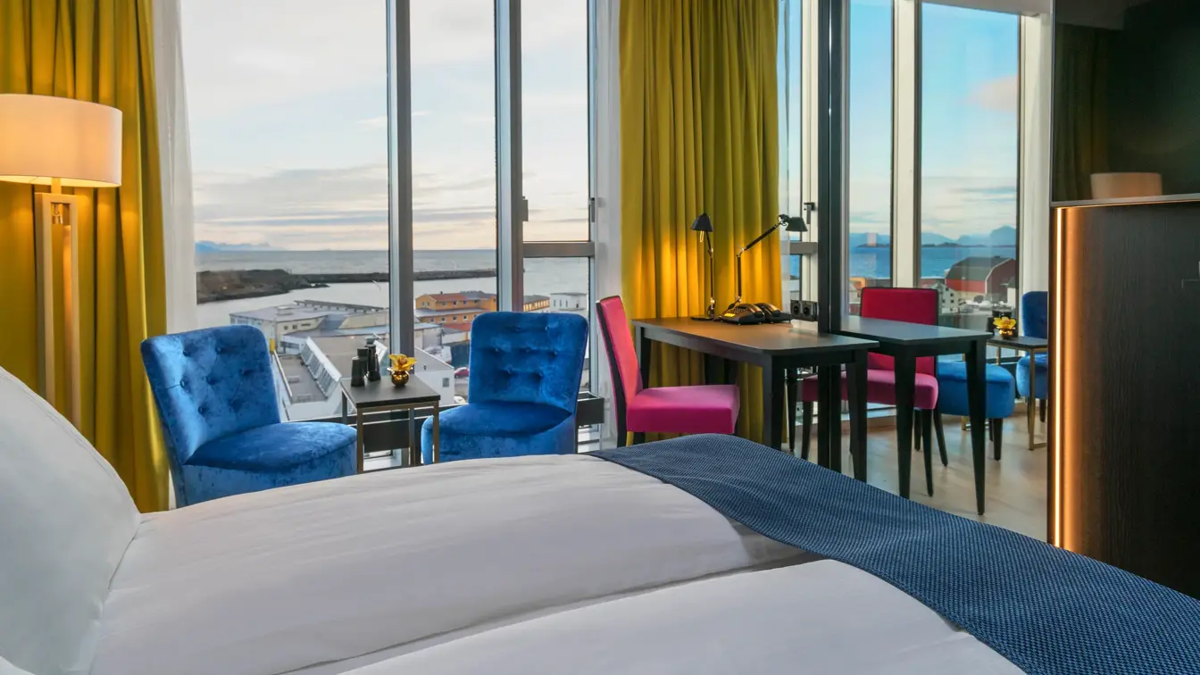 to stoler, dobbeltseng og skrivepult med utsikt på Superior room på Thon hotel Lofoten i Svolvær