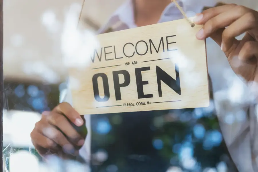 Young startup coffee cafe owener open and welcome customer. New small business owener.