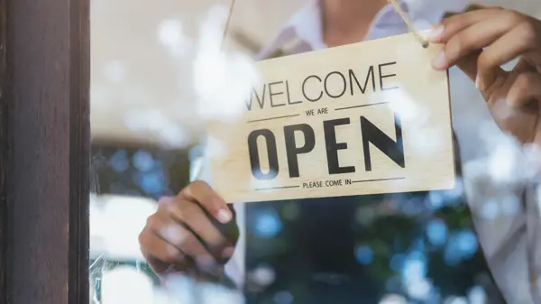 Young startup coffee cafe owener open and welcome customer. New small business owener.