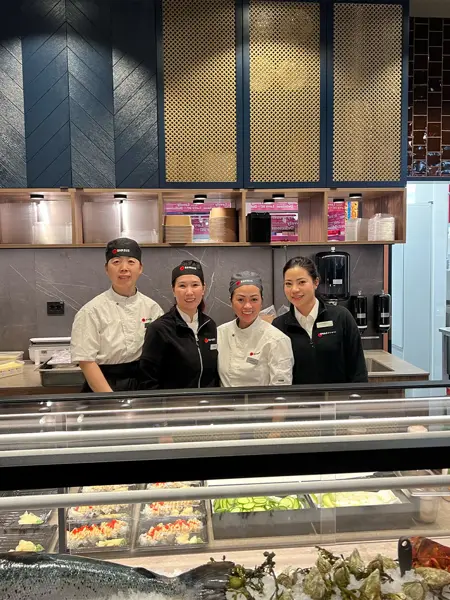 Fire personer som står bak disken