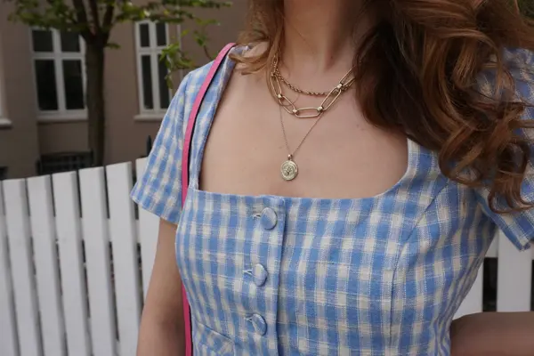 Nærbilde av kvinne med halssmykker som ligger lag på lag