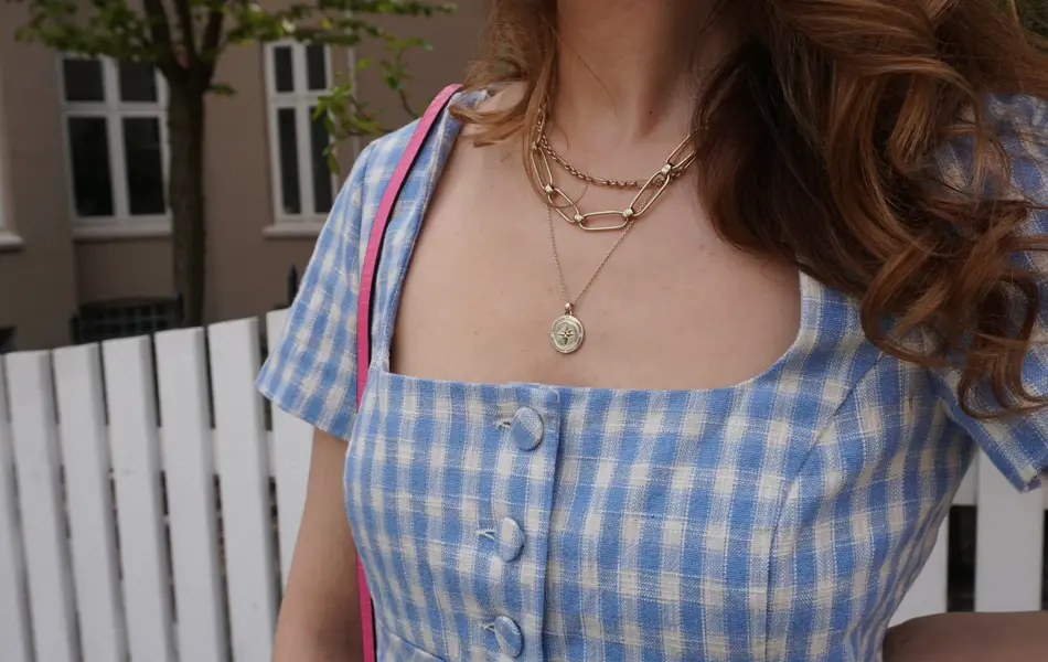 Nærbilde av kvinne med halssmykker som ligger lag på lag