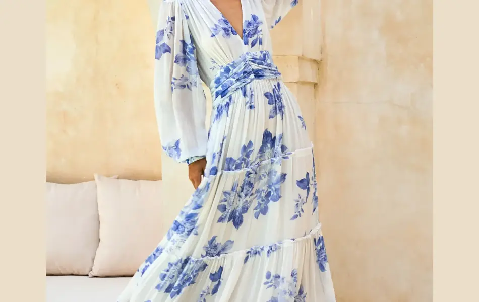 Dame med lang hvit og blåblomstrete kjole med lange ermer,