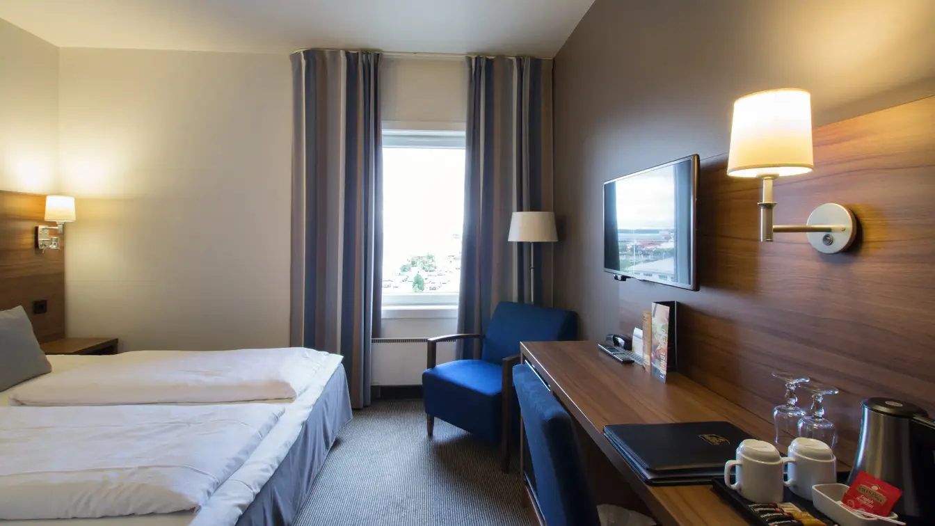 TV, skrivebord, med vannkoker med kaffe og TV, og seng i dobbeltrom på Thon Hotel Horten