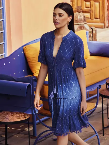 Dame i blå kjole som går i gaten