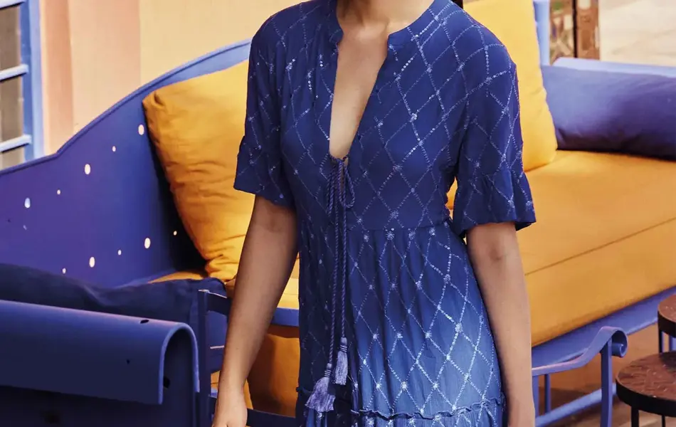 Dame i blå kjole som går i gaten