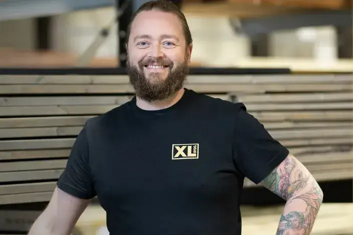 Mann fra XL-bygg smiler til kamera