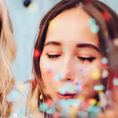 To damer som blåser på konfetti