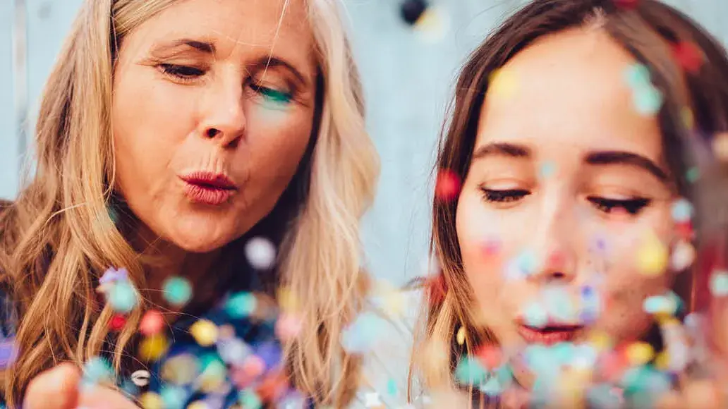 To damer som blåser på konfetti