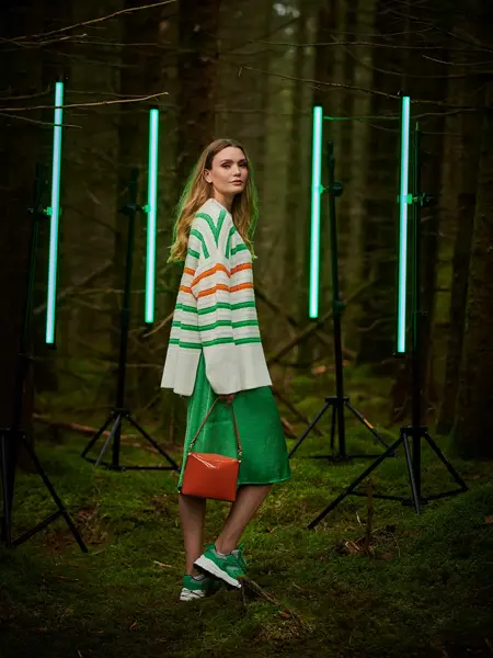 Dame i grønt antrekk i skogen