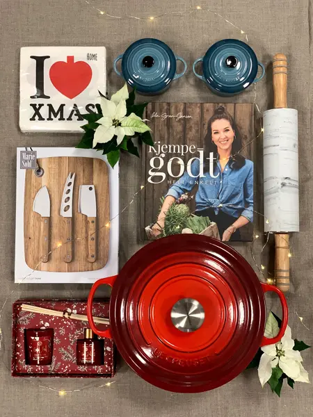 ulike produkter som le creuset gryter i blått og rødt, kjevle, ostekniver, kokeboken til ida gran jansen, duftlys, hvit julestjerne, servietter