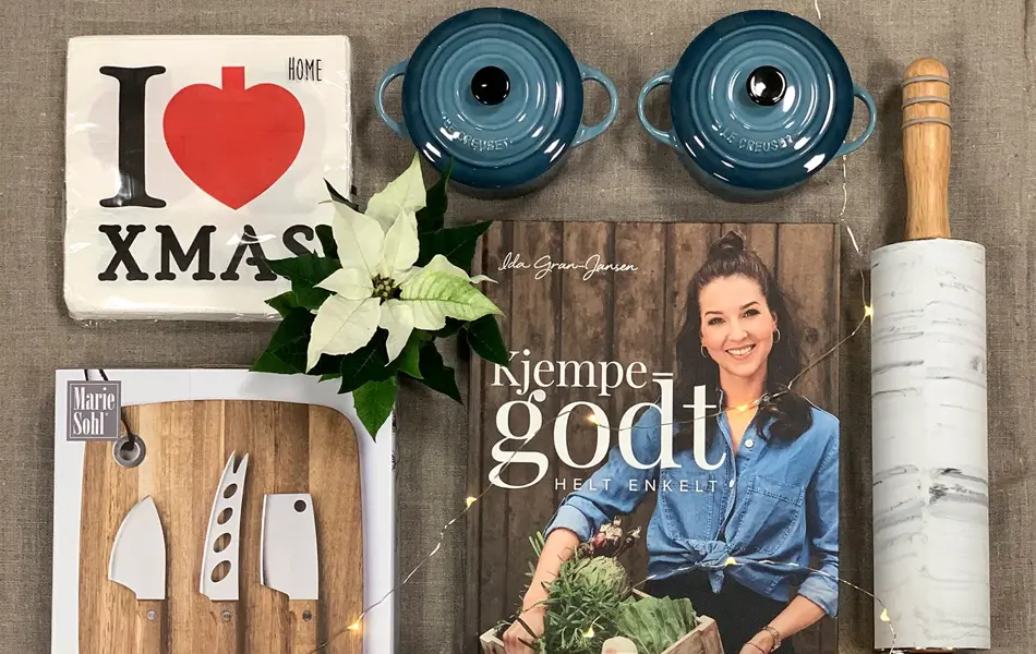 ulike produkter som le creuset gryter i blått og rødt, kjevle, ostekniver, kokeboken til ida gran jansen, duftlys, hvit julestjerne, servietter