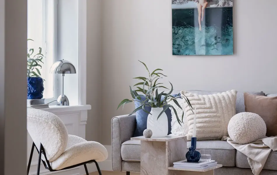 Stue med sofa, bord, stol og bilde på veggen