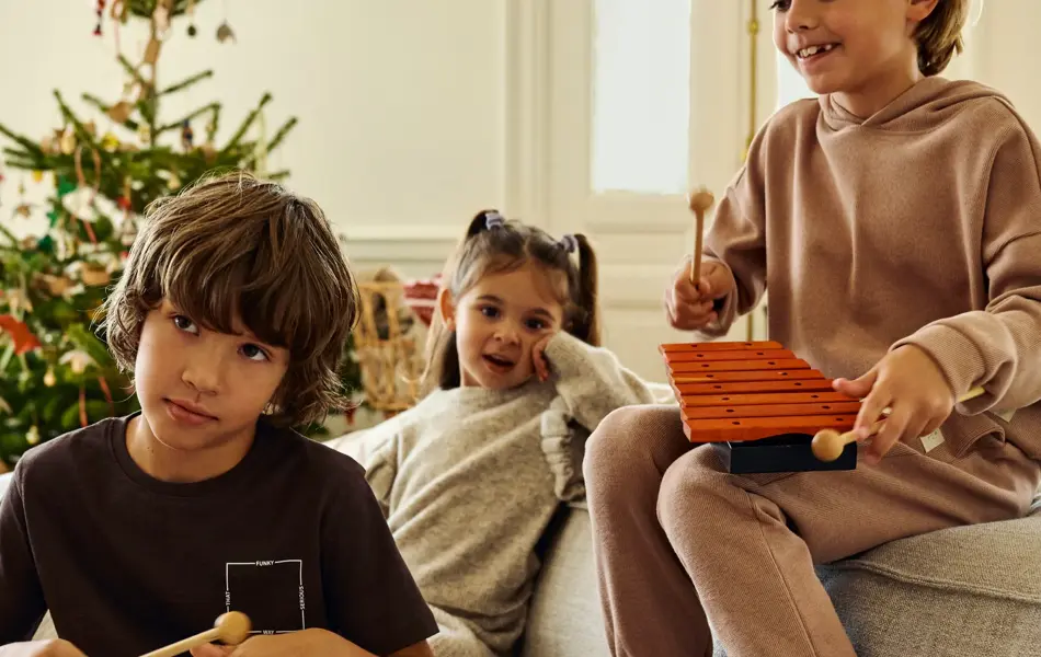 Barn som leker med musikkinstrument på en sofa