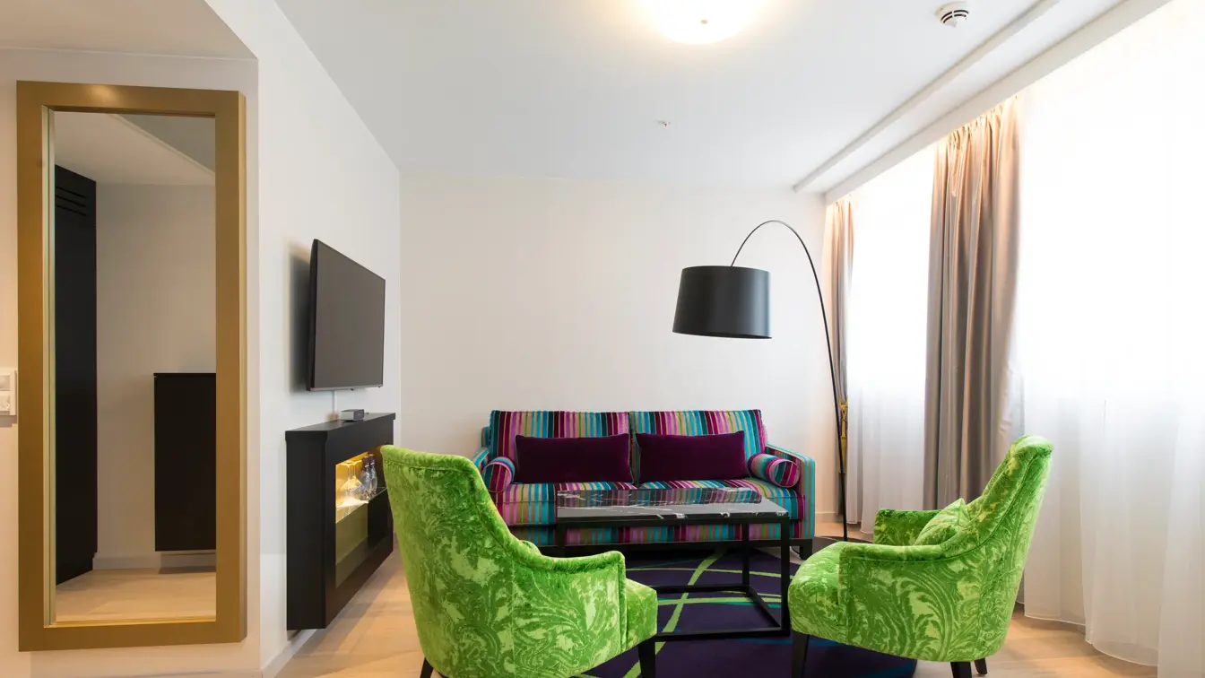 Sittegruppe med sofa og stoler, tv og lampe i buisness room på Thon Hotel Rosenkrantz Oslo, som ligger i Oslo sentrum
