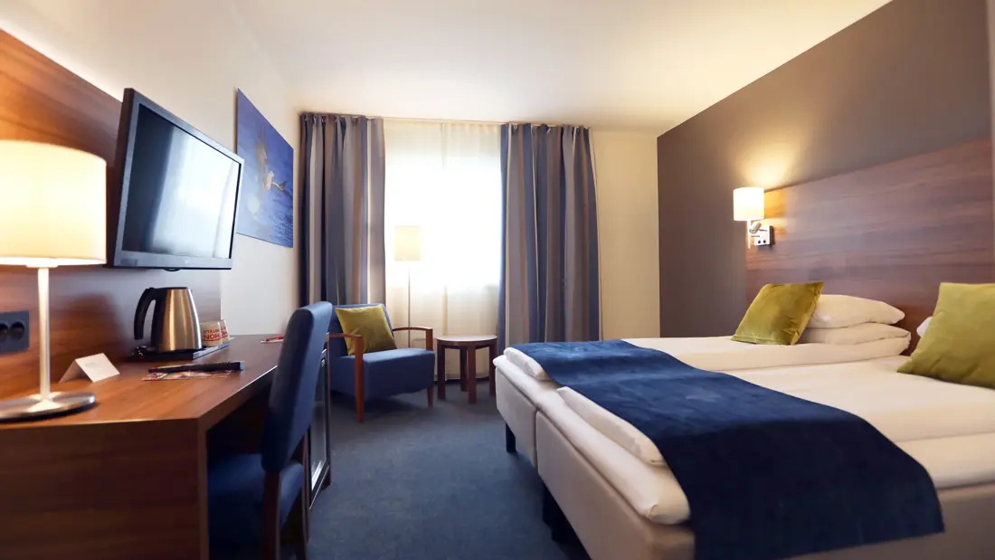 Skrivebord, TV, lenestol og dobbeltseng i dobbeltrom