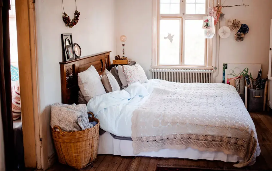 Soverom med flettede kurver og sengeteppe med blonder. Foto til artikkel om interiørtrender høsten 2023.