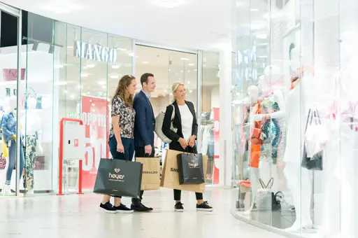 tre personer som shopper på senter
