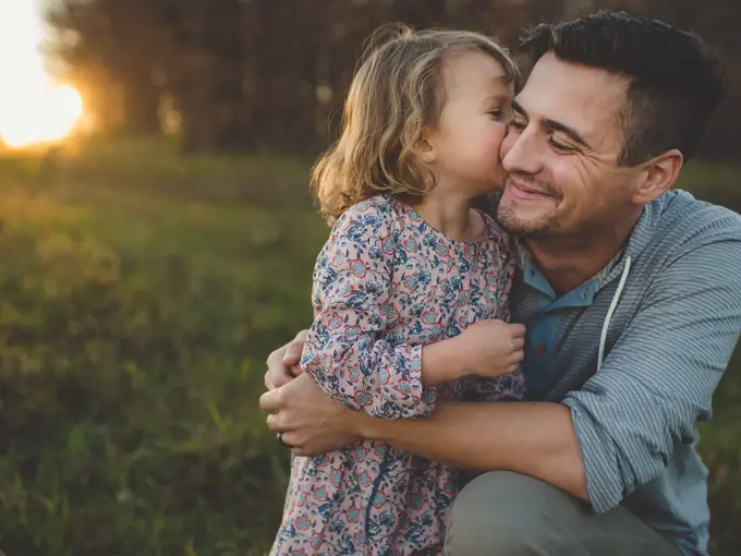 Jente kysser pappa på kinnet