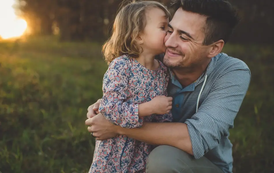 Jente kysser pappa på kinnet