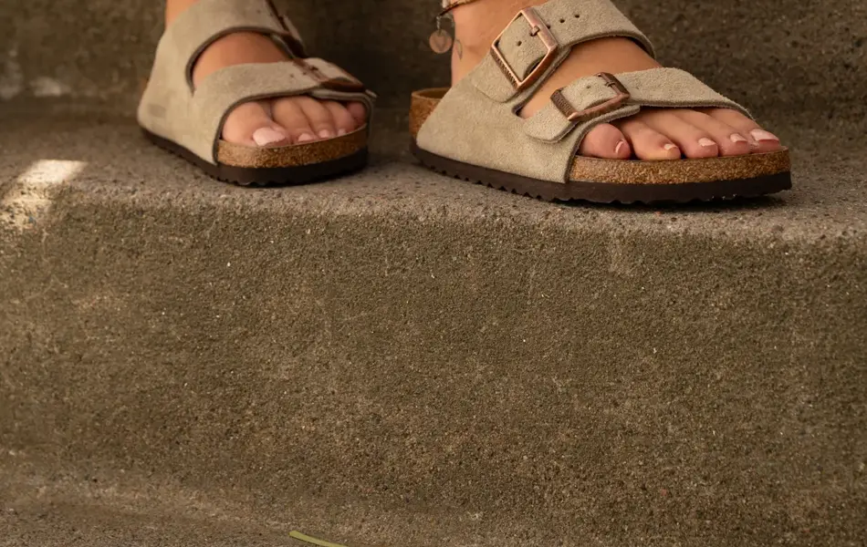 Ben med beige semsket Birckenstock og ankellenker.