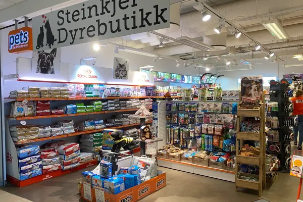 innendørs butikk med dyremat og skilter med tekst