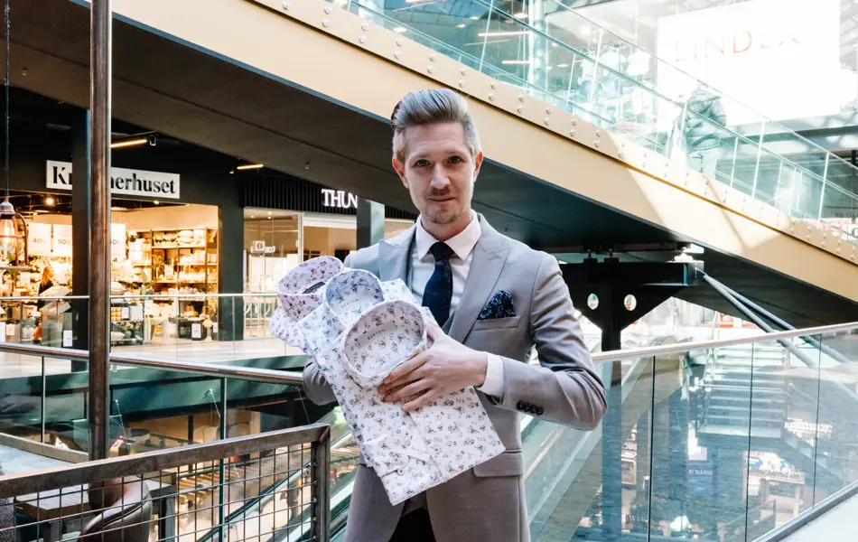 mann i dress holder skjorter