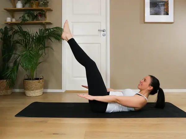 Anna viser Pilates-øvelser på treningsmatte på gulvet