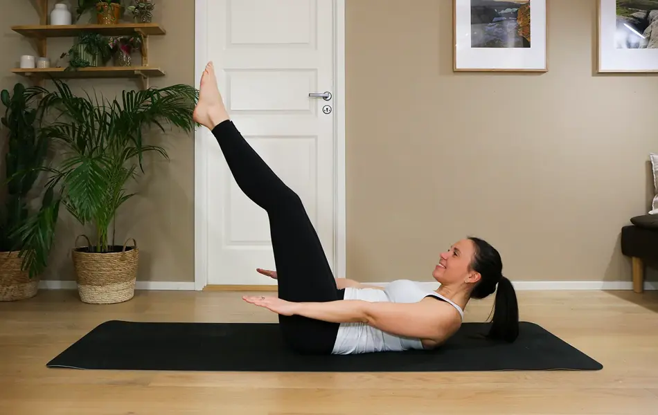 Anna viser Pilates-øvelser på treningsmatte på gulvet