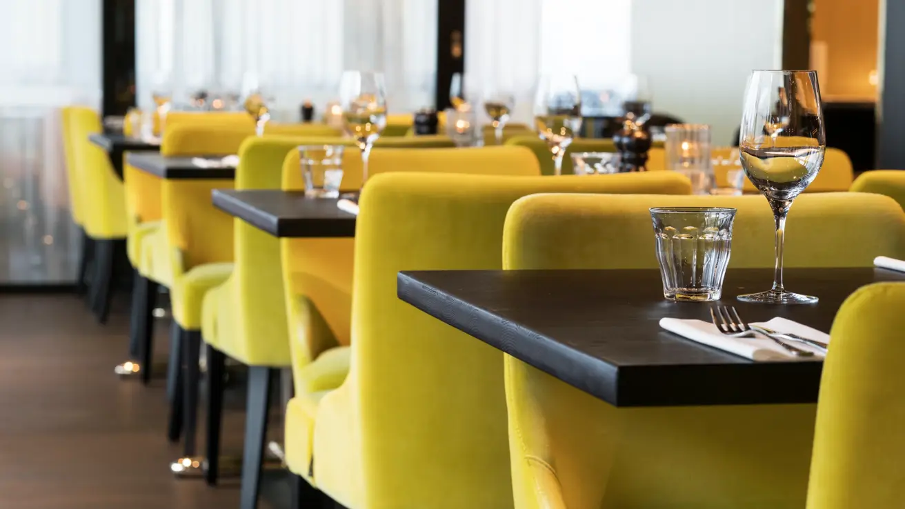 Frokostsal med gule stoler ved dekket bord på Thon Hotel Oslo Airport ved Gardermoen