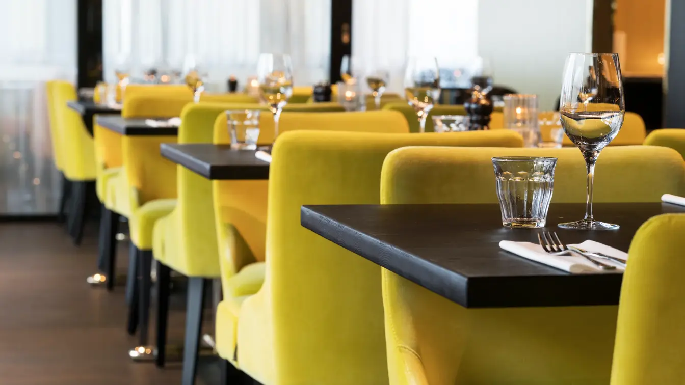 Frokostsal med gule stoler ved dekket bord på Thon Hotel Oslo Airport ved Gardermoen