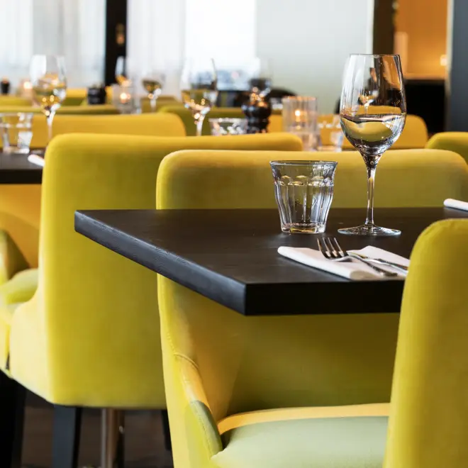 Frokostsal med gule stoler ved dekket bord på Thon Hotel Oslo Airport ved Gardermoen