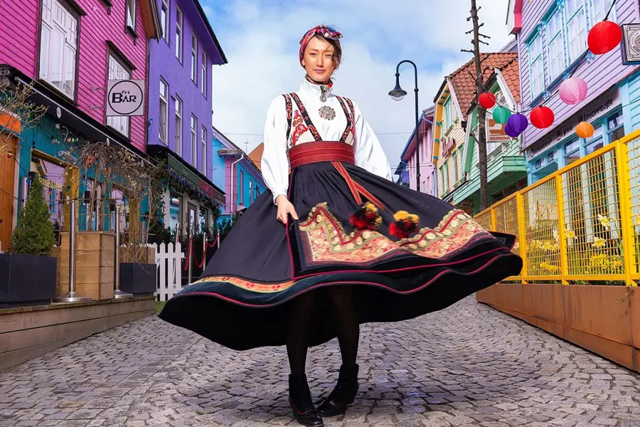 dame i bunad som står midt i stavanger fargegaten