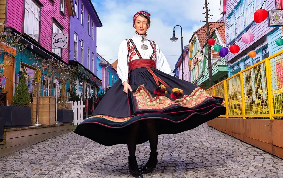 dame i bunad som står midt i stavanger fargegaten