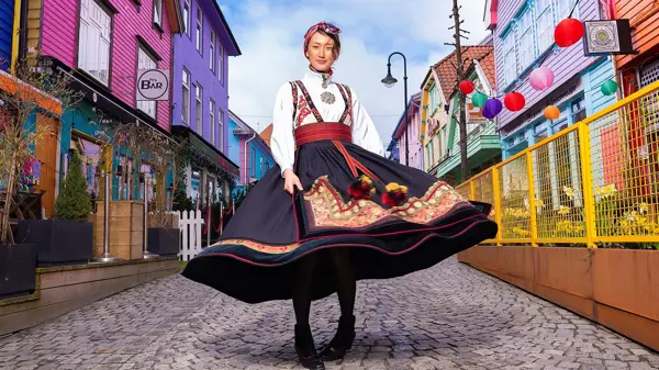 dame i bunad som står midt i stavanger fargegaten