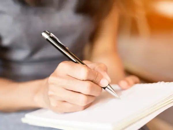 Women holding a pens writing a notebook. Recording concept