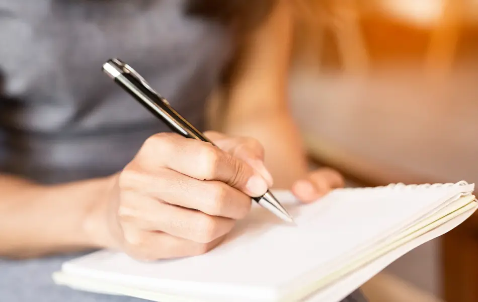 Women holding a pens writing a notebook. Recording concept
