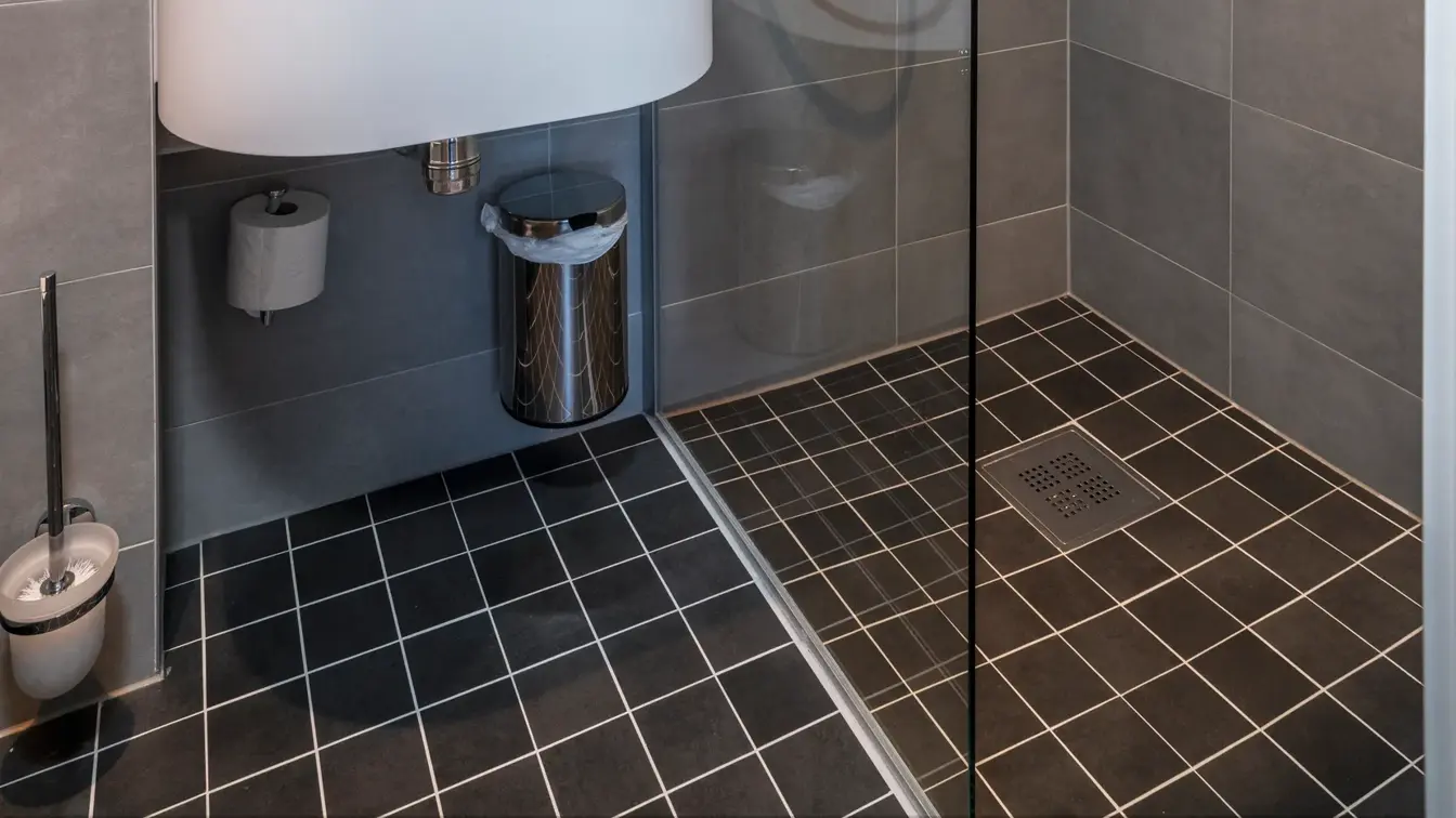 Vask, grå gulvfliser, grå veggfliser, dusj. speil